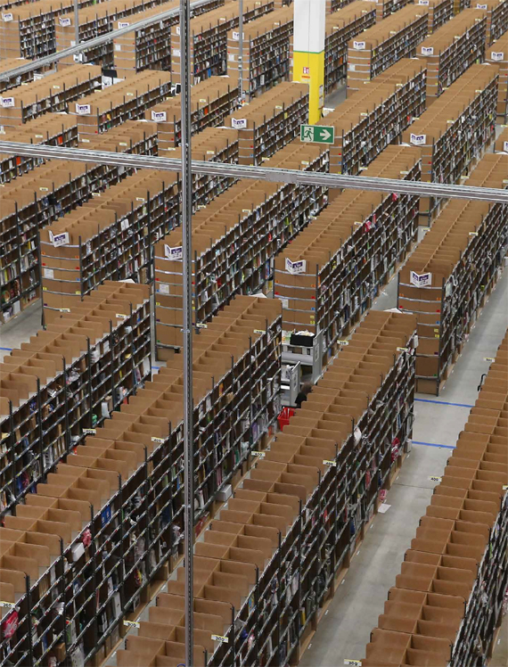 BBVA, OpenMind. Technological Progress and Potential Future Risks. WEst. Workers walk among shelves lined with goods at an Amazon warehouse, in Brieselang, Germany. Germany is online retailer Amazon’s second largest market after the USA.